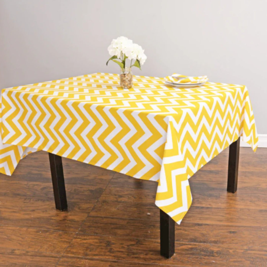 Yellow and white chevron tablecloth displayed on a dining table.