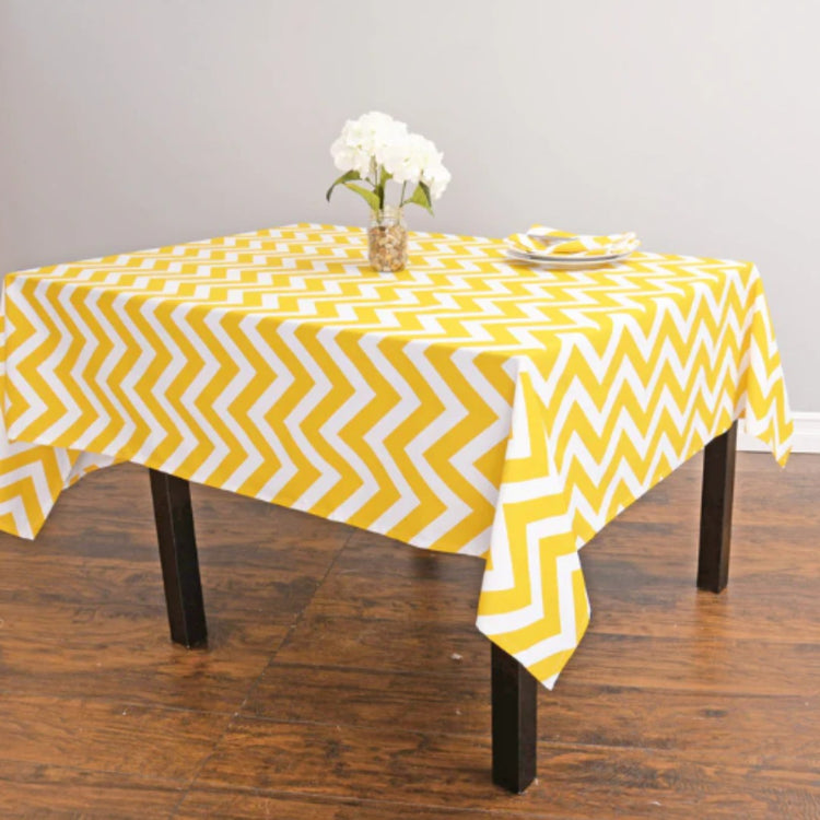Yellow and white chevron tablecloth displayed on a dining table.