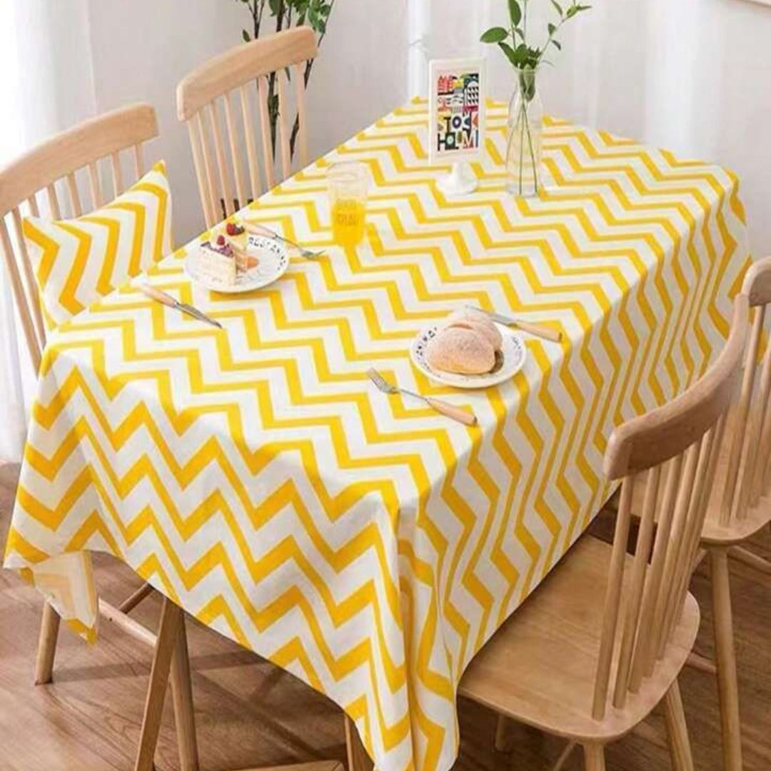 Yellow and white chevron tablecloth displayed on a dining table.