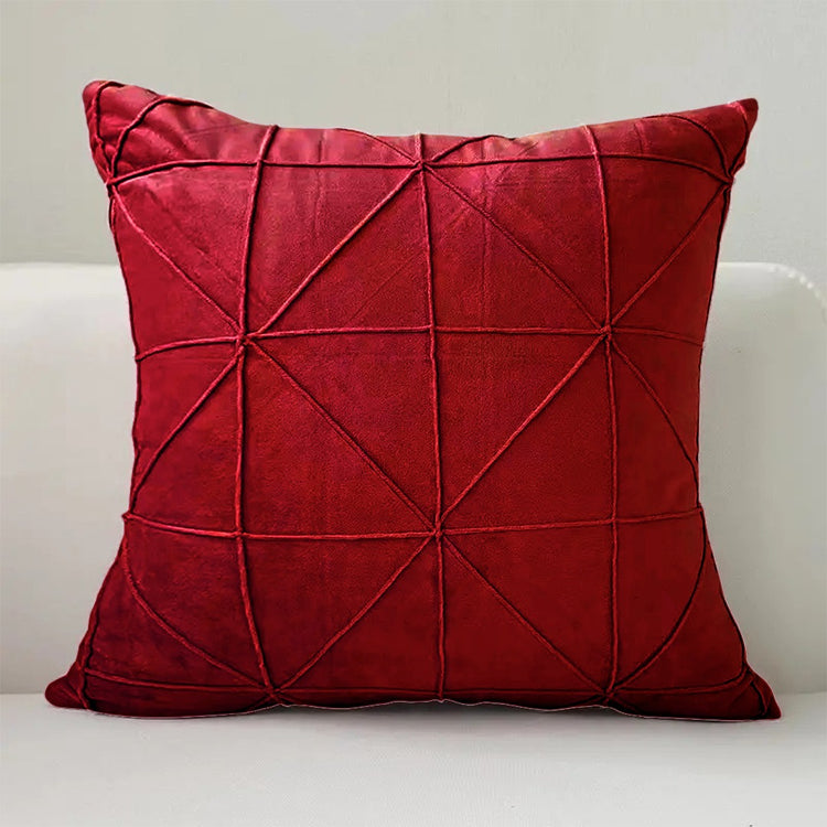 Red cushion cover with intersecting geometric stitched lines.