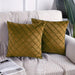 Two ochre cushion covers with diamond stitching on a sofa.