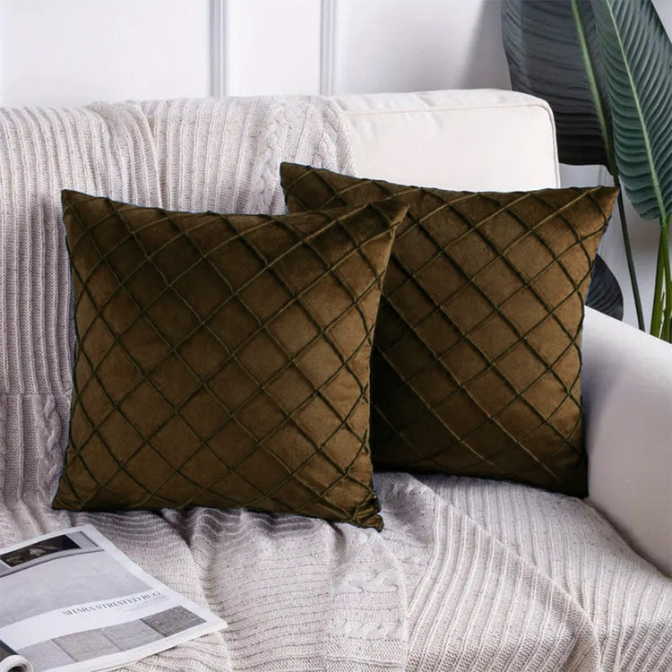 Two dark brown cushion covers with diamond stitching on a sofa.