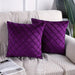 Two purple cushion covers with diamond stitching on a sofa.