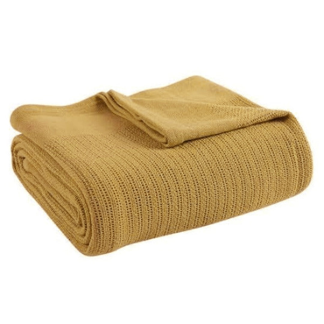 Folded mustard yellow ribbed cotton thermal blanket.