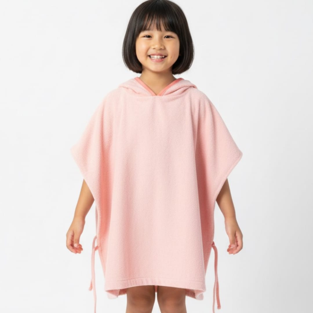 Child wearing a plain pink hooded towel poncho.