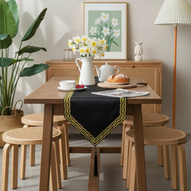 Black velvet table runner with a gold geometric border and pointed ends.