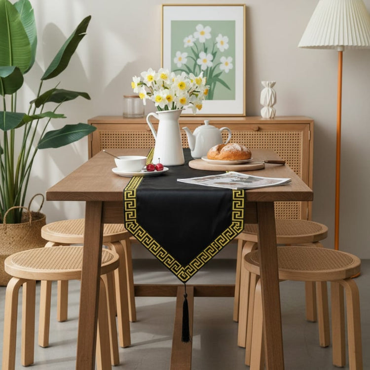 Black velvet table runner with a gold geometric border and pointed ends.