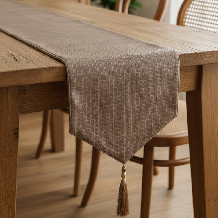 Textured taupe table runner with a pointed end on a wooden table.
