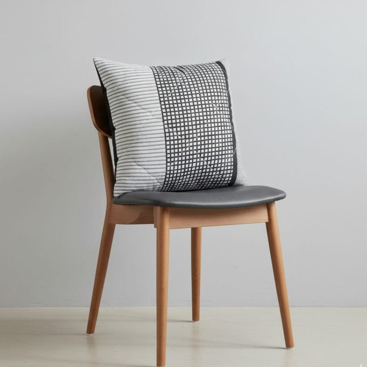 Grey cushion cover with a fine textured pattern displayed on a chair.