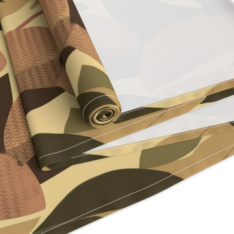 Close view of an autumn leaf-pattern table runner partly rolled on a table.