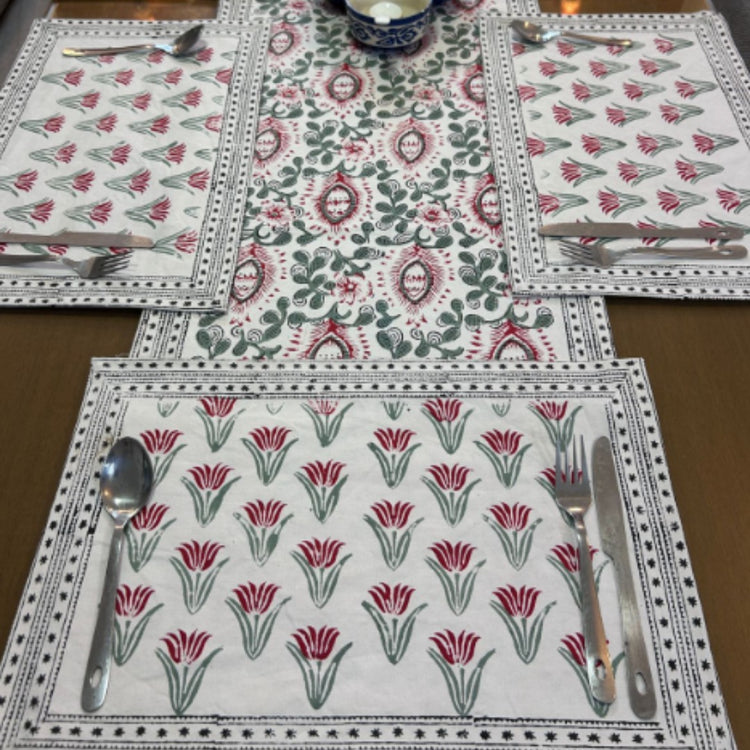 Close view of a floral table runner and matching placemats with decorative borders.