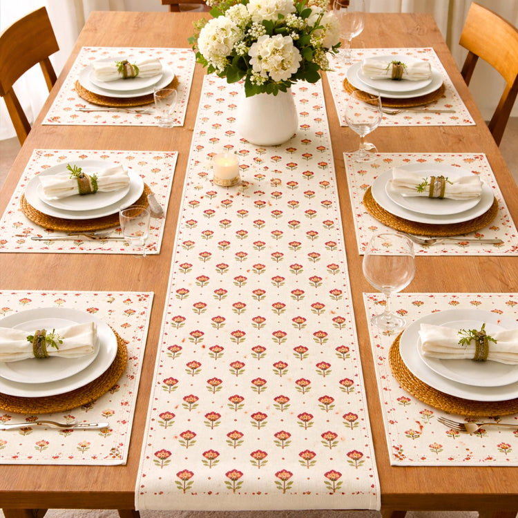 Cream table runner with small repeating red floral motifs and matching placemats.