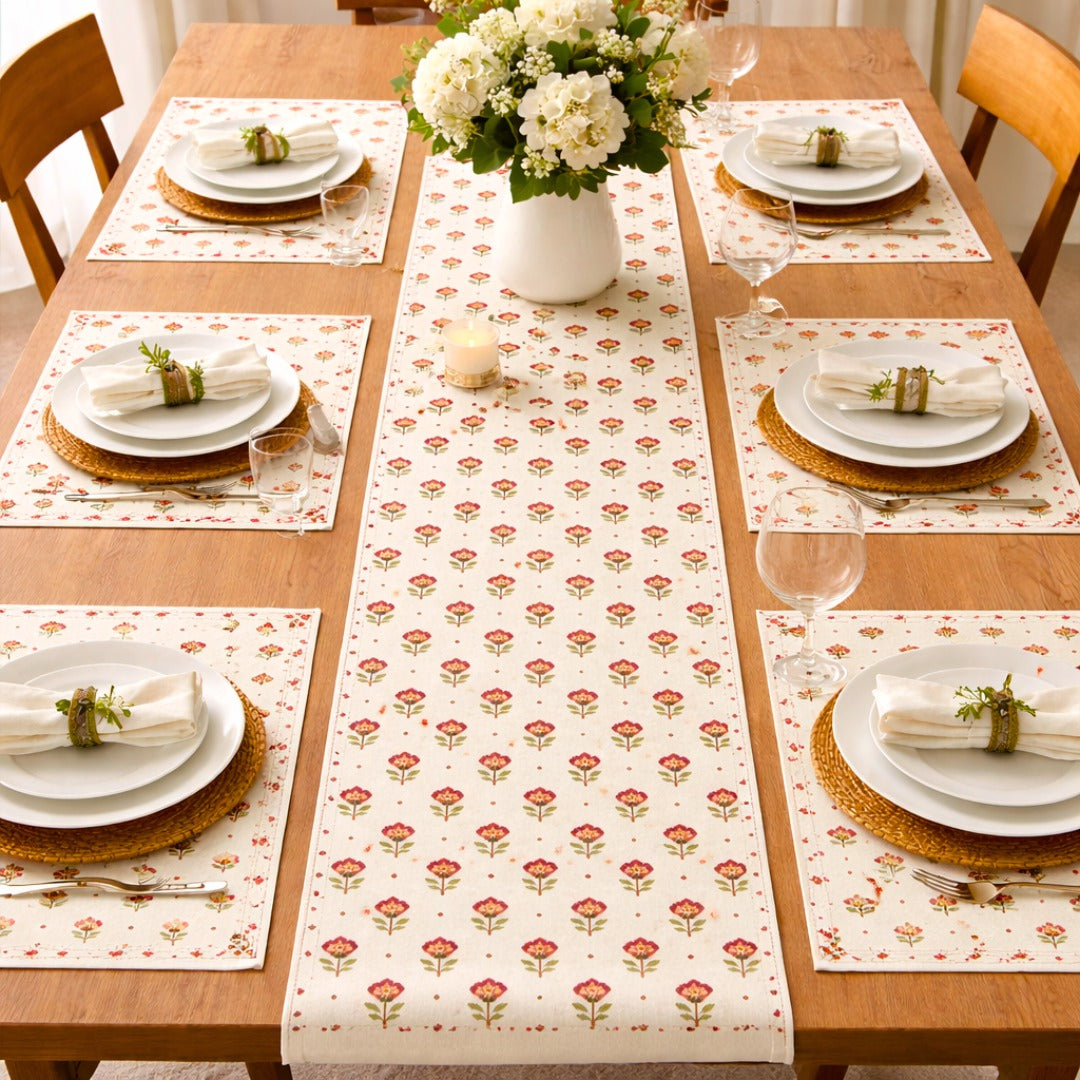 Cream table runner with small repeating red floral motifs and matching placemats.