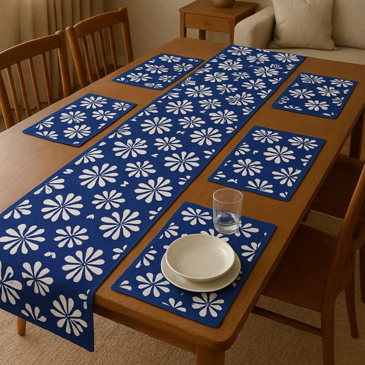 Blue table runner with white floral motifs and matching placemats.