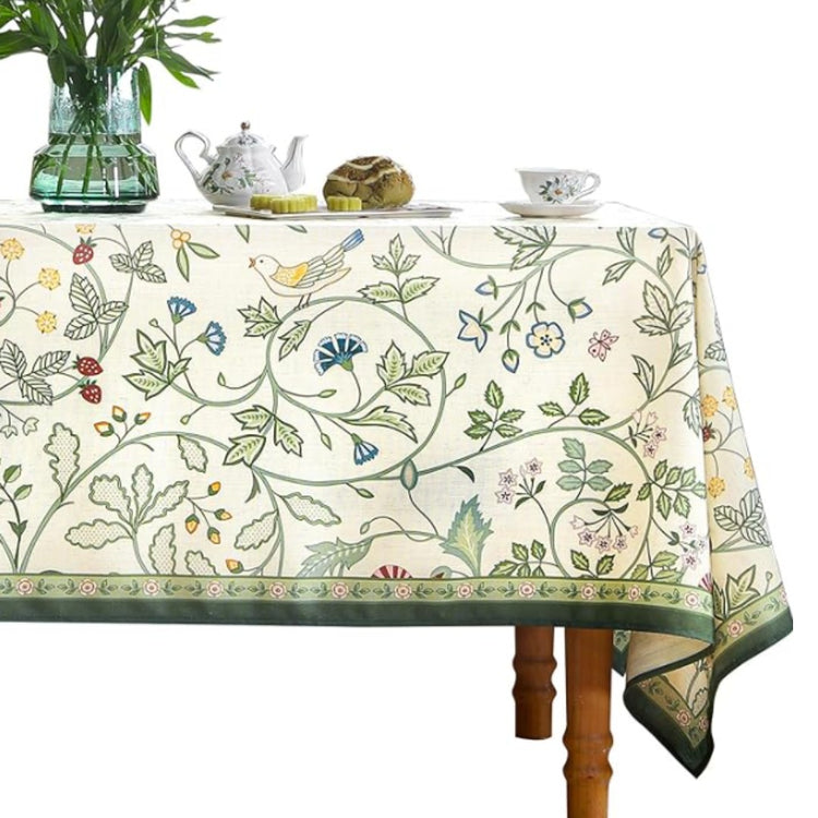 Cream tablecloth with delicate green and blue botanical vines and a green border.