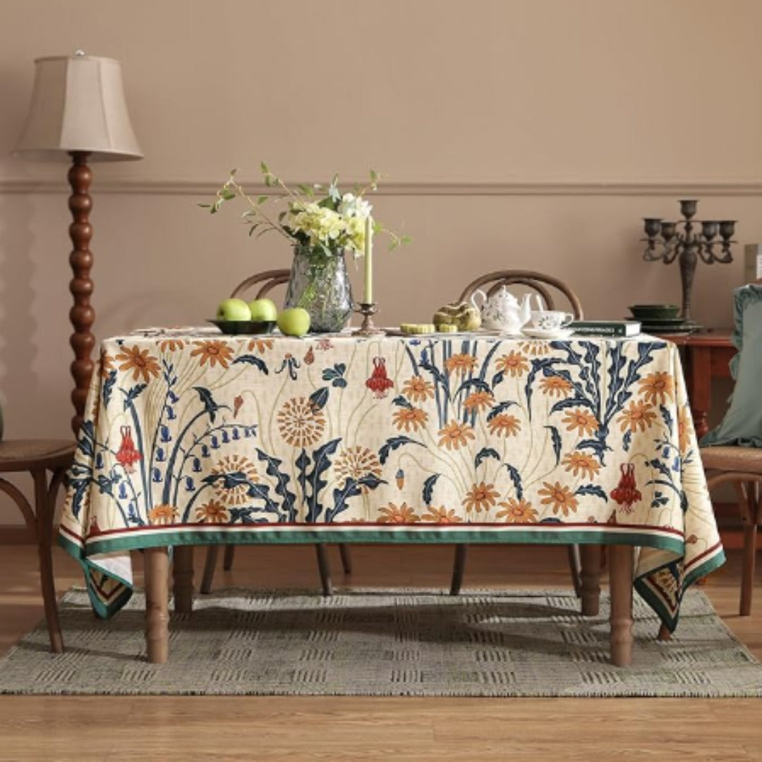 Cream tablecloth with orange and navy botanical motifs and contrasting borders.
