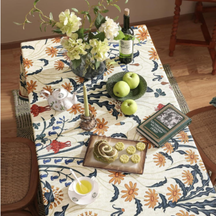 Cream tablecloth with orange and navy botanical motifs and contrasting borders.