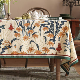 Cream tablecloth with orange and navy botanical motifs and contrasting borders.