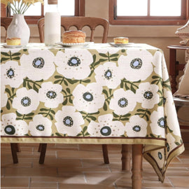 White tablecloth with repeating green ornamental floral medallions.