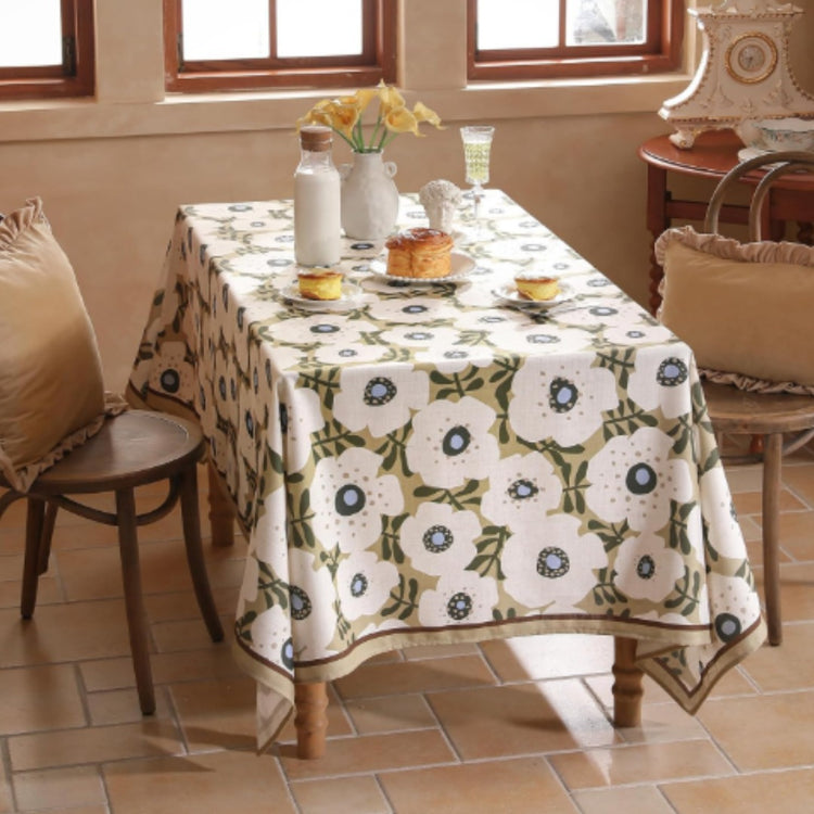 White tablecloth with repeating green ornamental floral medallions.