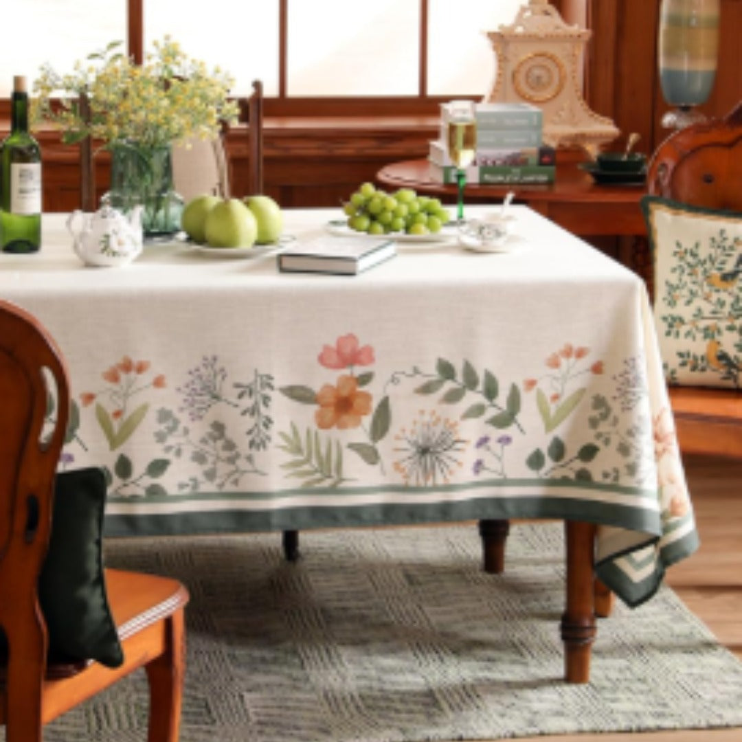 Cream tablecloth with scattered flowers and a wide green border.