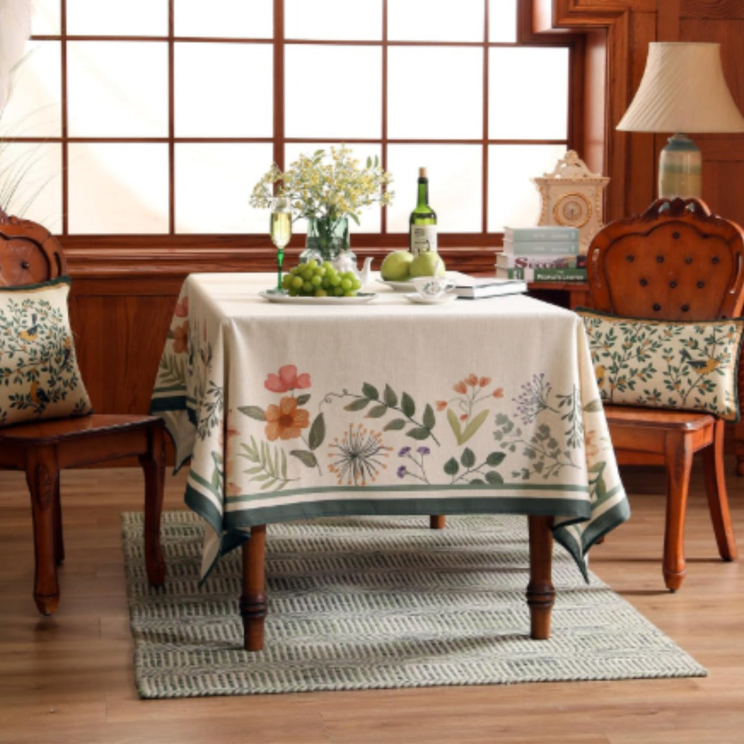Cream tablecloth with scattered flowers and a wide green border.