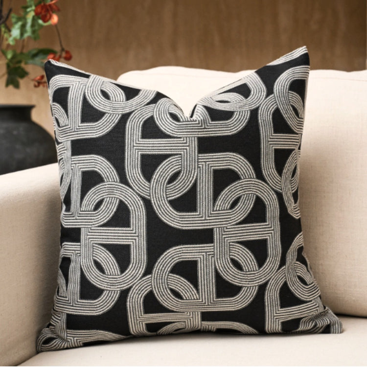 Black cushion cover with an interlocking grey curved geometric pattern.