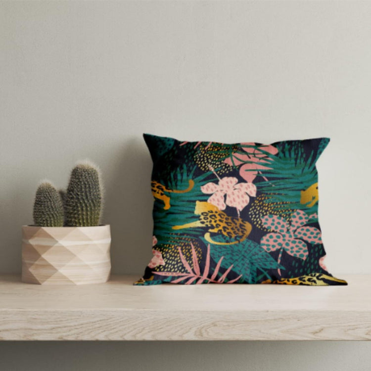 Dark green cushion cover with a spotted big cat, pink flowers and tropical leaves.