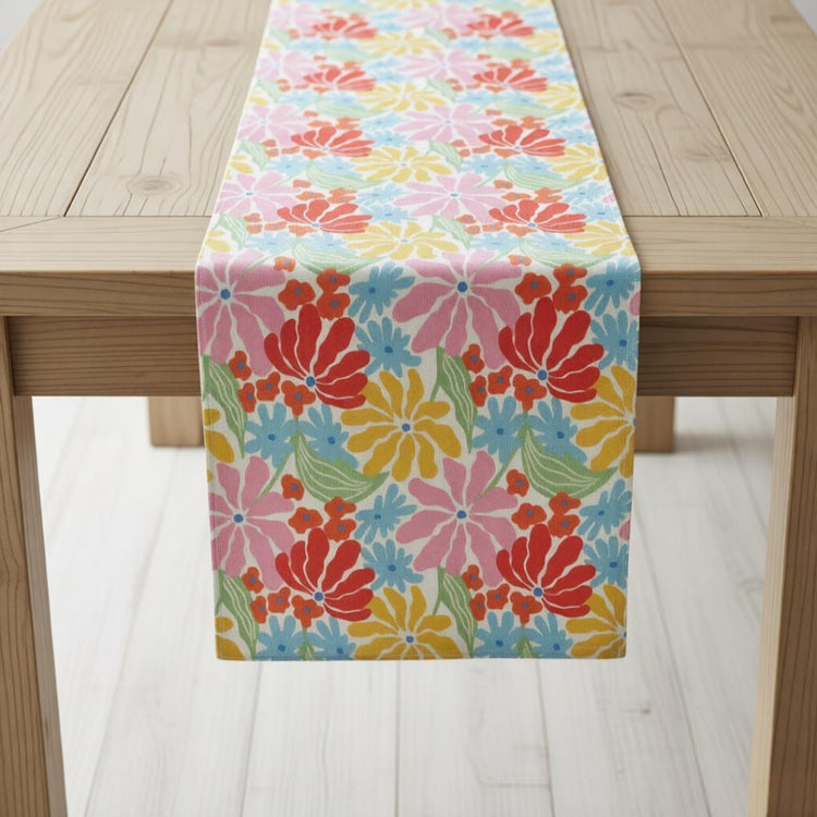 Table runner with bright pink, orange and yellow flowers on a pale blue background.