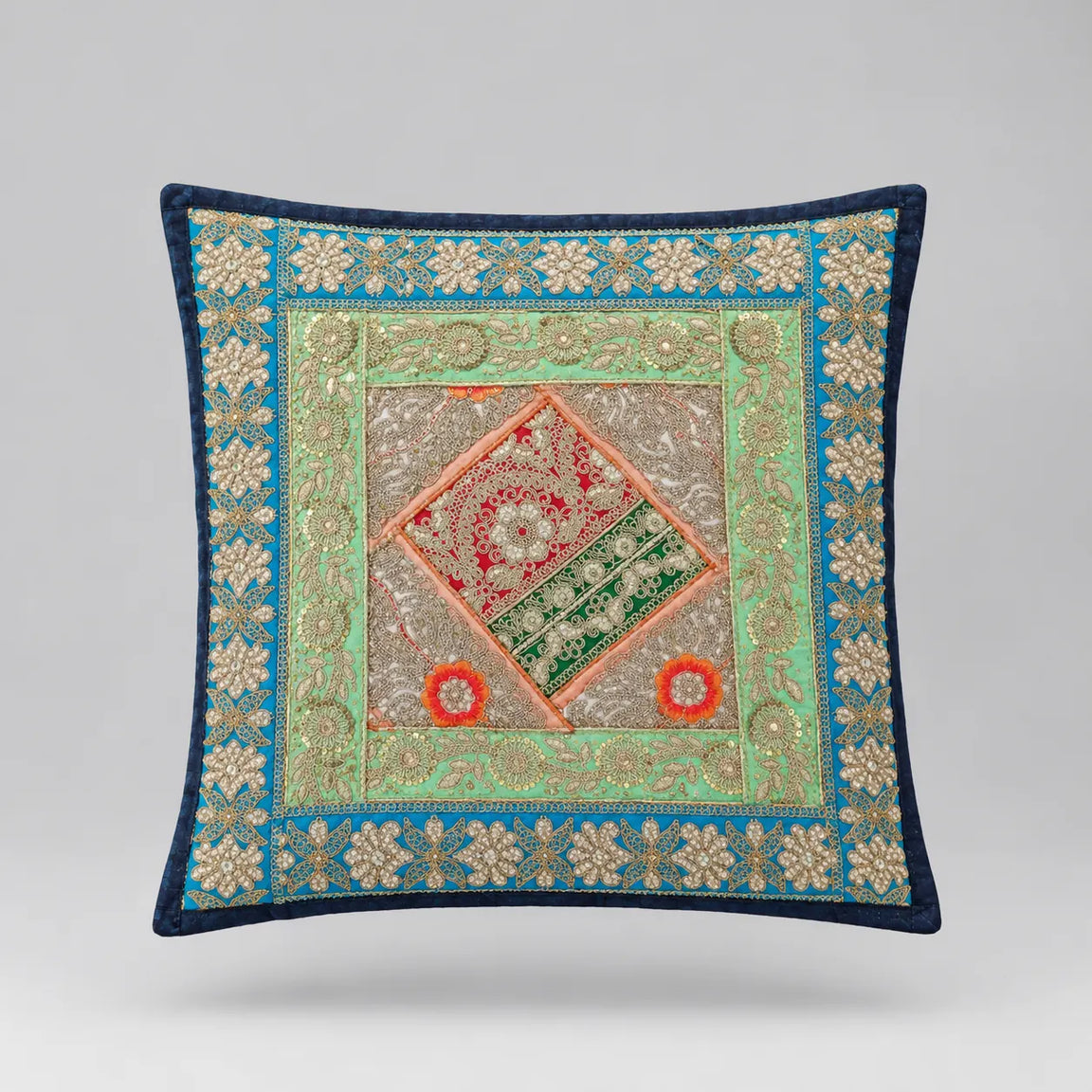 Navy-bordered cushion cover with turquoise and pale gold coloured floral borders and a central diamond.