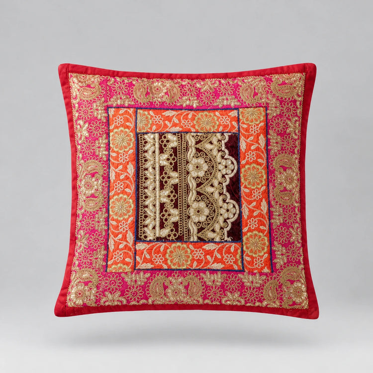 Red-bordered cushion cover with ornate pink and gold coloured floral bands and a dark patterned centre.