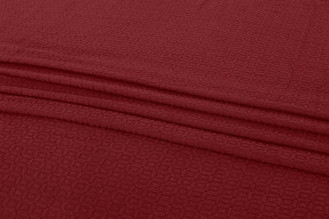 Close-up of burgundy cotton thermal blanket fabric.