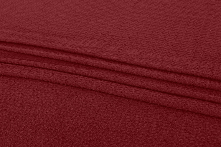 Close-up of burgundy cotton thermal blanket fabric.