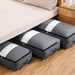 Grey flat quilt-storage bags arranged beneath a bed.