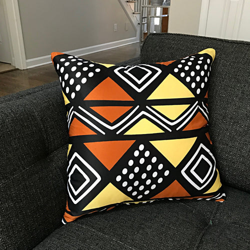 Black cushion cover with orange, yellow and cream triangles, diamonds and dotted panels.