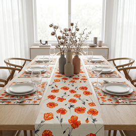 White table runner with orange and red flowers and matching placemats.