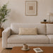 Rectangular cream filled cushion with intersecting geometric stitching on a cream sofa.