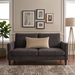 Rectangular cream filled cushion with diamond stitching on a dark grey sofa.