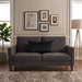 Rectangular black filled cushion with diamond stitching on a dark grey sofa.