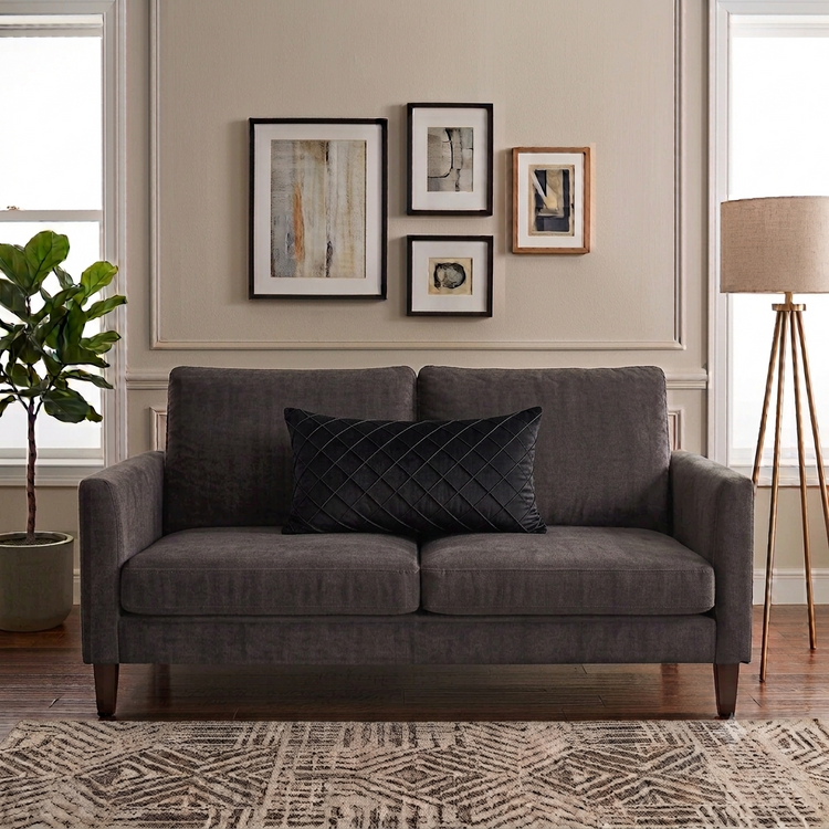 Rectangular black filled cushion with diamond stitching on a dark grey sofa.