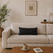 Rectangular black filled cushion with intersecting geometric stitching on a cream sofa.