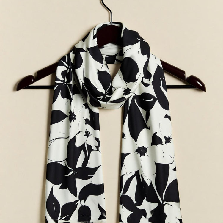 Black and white floral scarf displayed on a dark hanger.