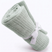 Rolled pale mint cellular blanket tied with a white ribbon.
