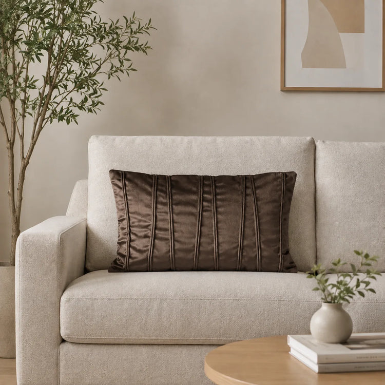 Rectangular brown filled cushion with vertical stitched texture on a cream sofa.