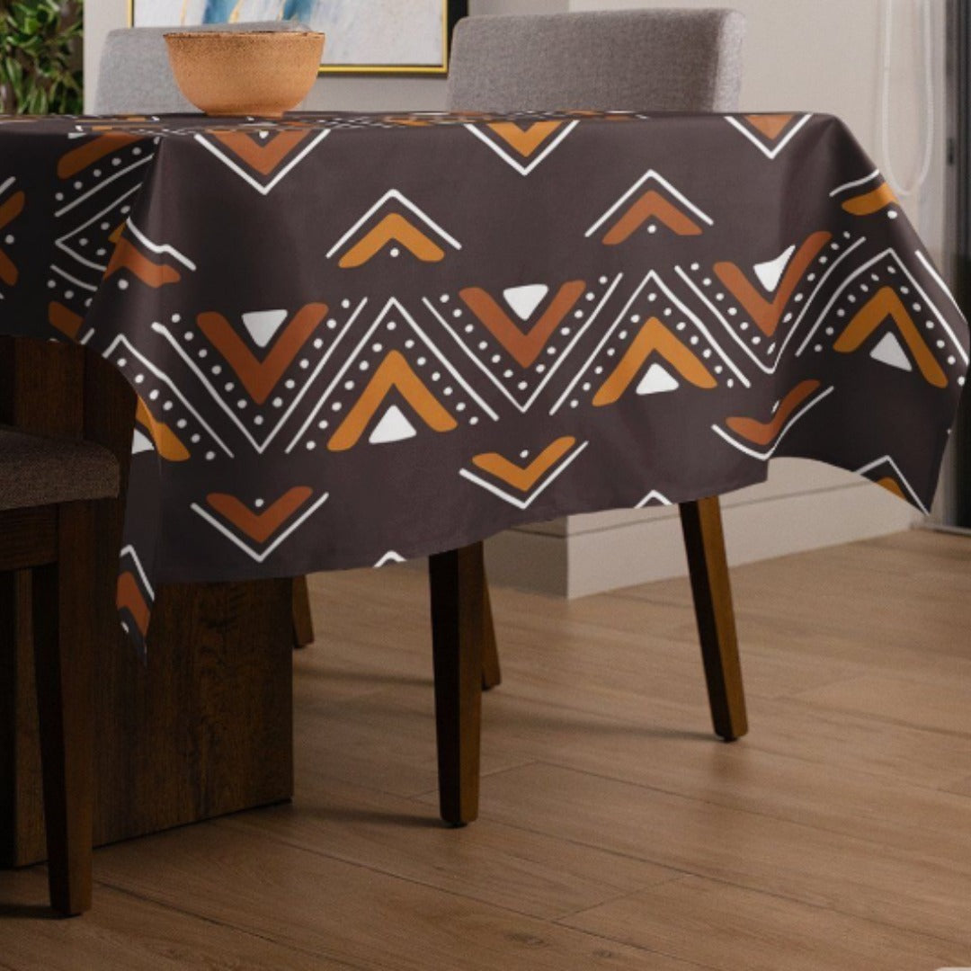 Dark brown tablecloth with orange, cream and black geometric bands.