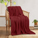 Burgundy cotton thermal blanket draped over a wooden armchair.