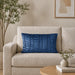 Rectangular blue filled cushion with vertical stitched texture on a cream sofa.