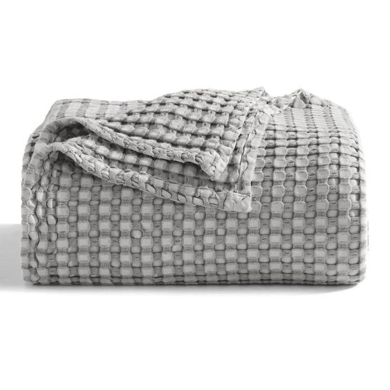 Folded grey waffle-weave blanket on a white background.