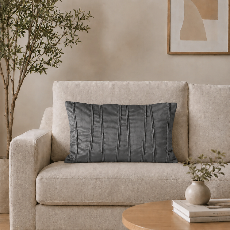Rectangular dark grey filled cushion with vertical stitched texture on a cream sofa.