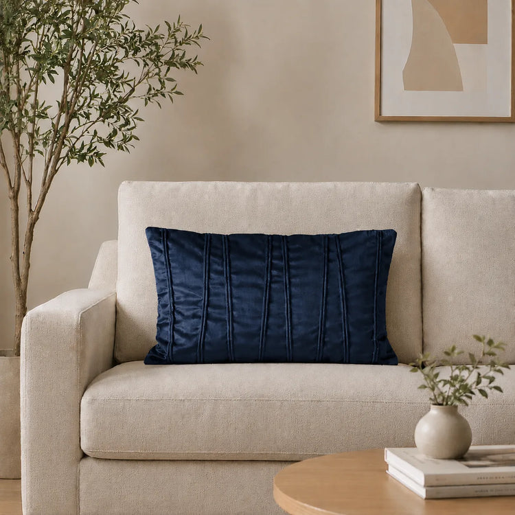 Rectangular navy filled cushion with vertical stitched texture on a cream sofa.
